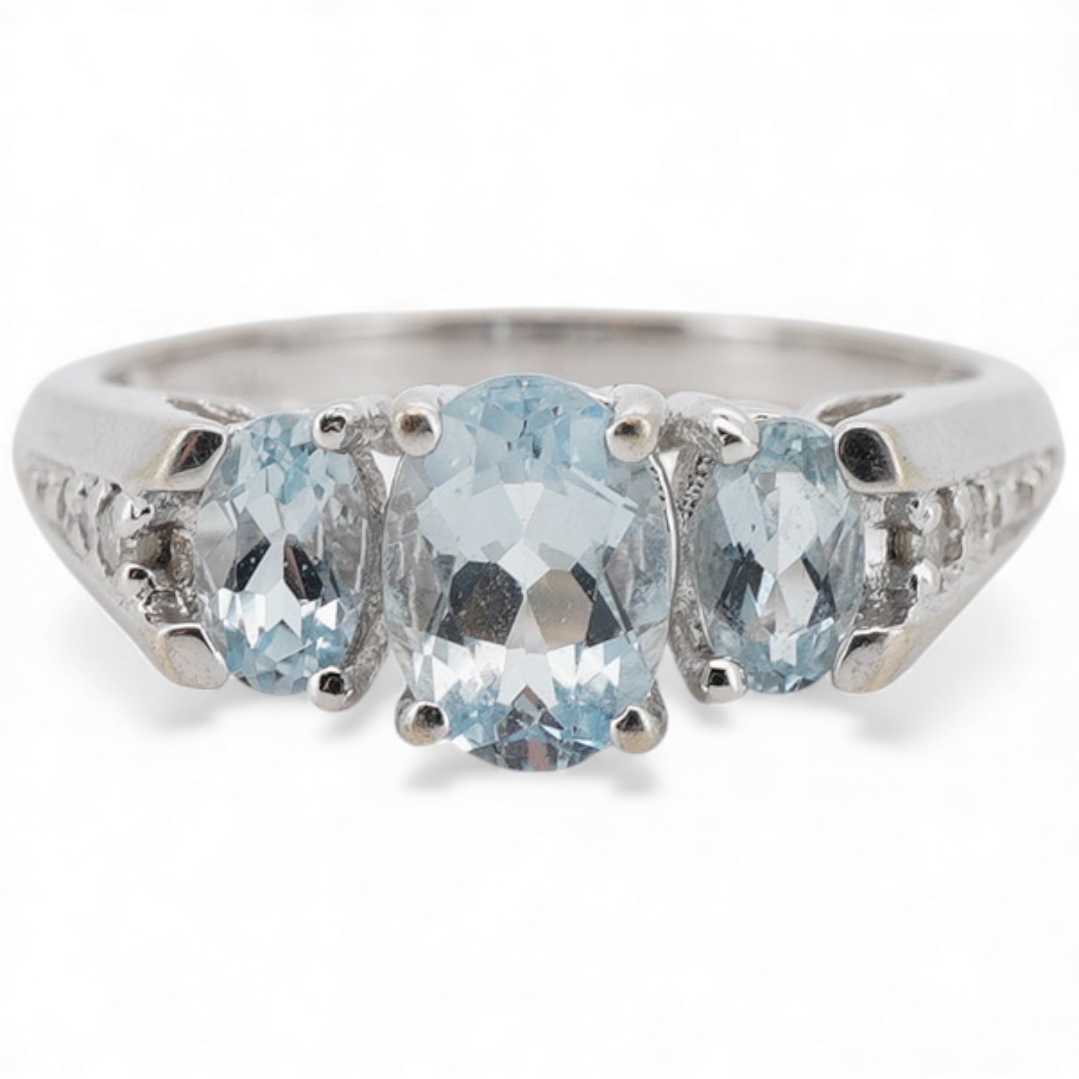A modern 10k white metal and three stone oval cut aquamarine ring, with six stone diamond chip set shoulders, size N, gross weight 2.7 grams.